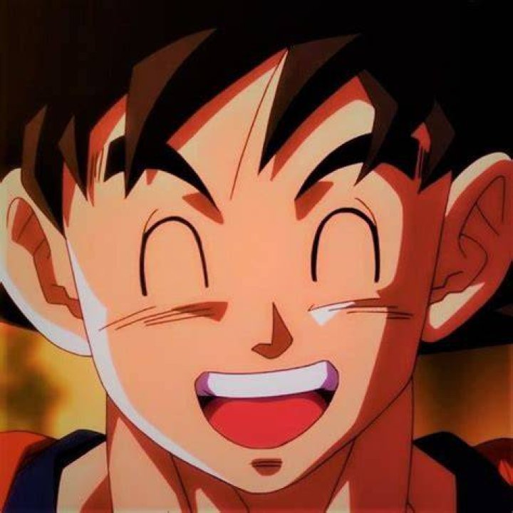 Goku is smiling and holding his arm behind his head.