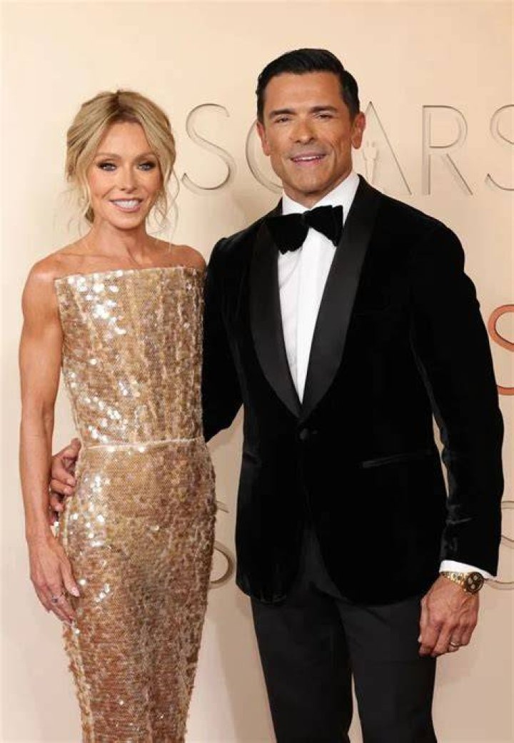 Kelly Ripa on the Oscars red carpet wearing a black dress, dark eyeshadow, and her signature blond hair