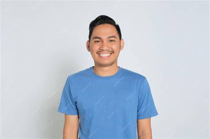 man in blue tshirt smiling at camera