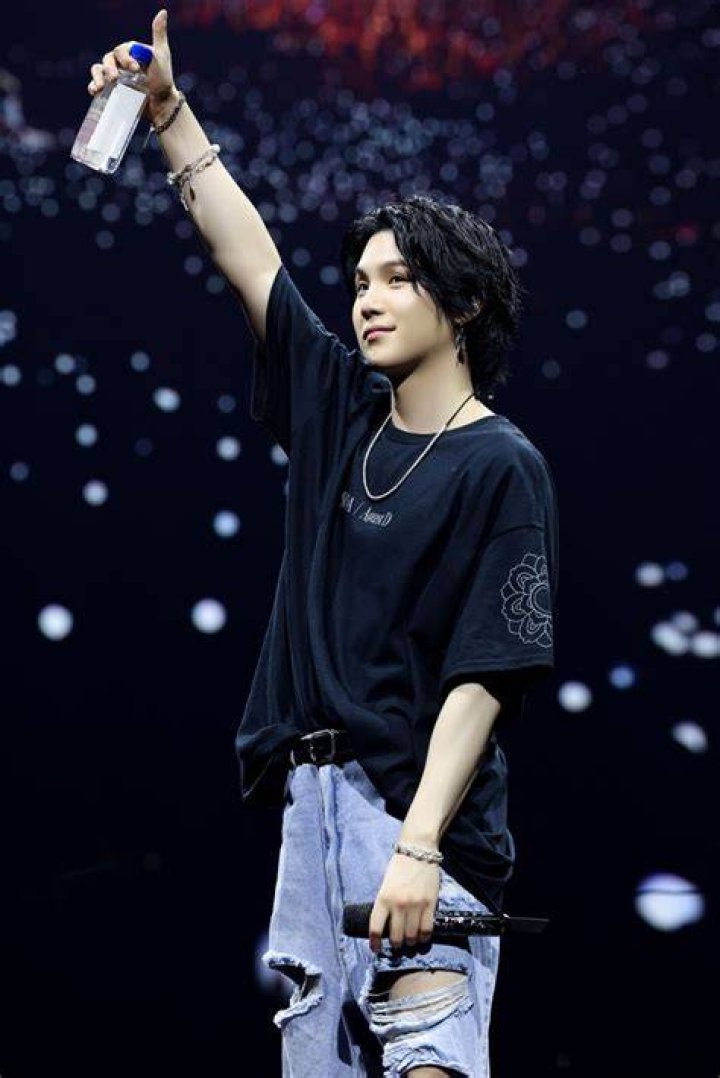 SUGA performing with an electric guitar during the 'D-DAY' Tour.